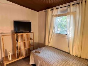 Un dormitorio con una cama y un televisor y una ventana. en Ancient Pydna Paradise, en Makrygialos