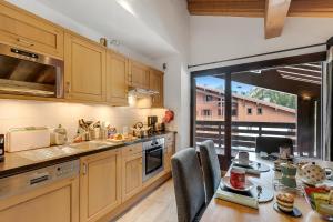 uma cozinha com uma mesa e uma sala de jantar em l'Ours Bleu B33 ski -in ski -out - Happy Rentals em Vallorcine