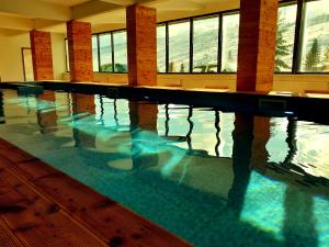 a large swimming pool with water in a building at Hotel Arena - Teteks in Tetovo