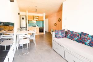 a living room with a white couch and a kitchen at Vizazi Loft in Dambani