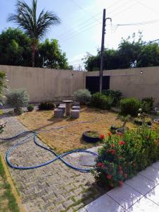 ein Garten mit einem auf dem Boden liegenden Gartenschlauch in der Unterkunft Flat do Rafa in Caucaia