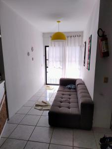ein Wohnzimmer mit einer braunen Couch in einem Zimmer in der Unterkunft Flat do Rafa in Caucaia