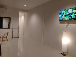 a white room with a television on a wall at Sheep House บ้านนับแกะ in Ban Don Rak
