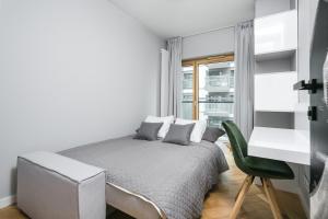 une chambre blanche avec un lit et un bureau dans l'établissement Golden Apartments Warsaw - Luxury 2-Bedroom, Mennica Residence&166, à Varsovie
