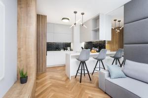 une cuisine et un salon avec un canapé et une table dans l'établissement Golden Apartments Warsaw - Luxury 2-Bedroom, Mennica Residence&166, à Varsovie