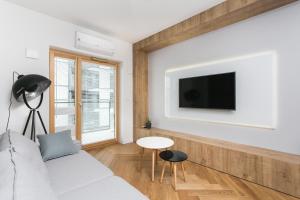 un salon avec un canapé et une télévision fixée au mur dans l'établissement Golden Apartments Warsaw - Luxury 2-Bedroom, Mennica Residence&166, à Varsovie