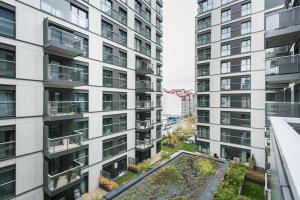 un immeuble d'appartements avec un jardin au milieu dans l'établissement Golden Apartments Warsaw - Luxury 2-Bedroom, Mennica Residence&166, à Varsovie