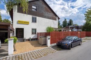 ein schwarzes Auto, das vor einem Haus geparkt ist in der Unterkunft Aparmtent im Münchner Westen, Parkplatz kostenfrei, ruhig in Gröbenzell