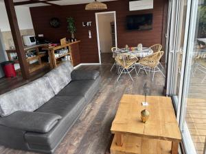 ポルティシオにあるCHALET de la plageのソファとテーブルのあるリビングルーム +4枚の写真