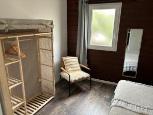ポルティシオにあるCHALET de la plageのベッドルーム1室(二段ベッド、椅子、窓付)