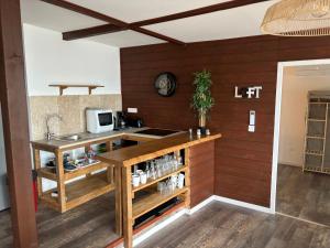 ポルティシオにあるCHALET de la plageの木製の壁のキッチン、シンク付きのカウンター