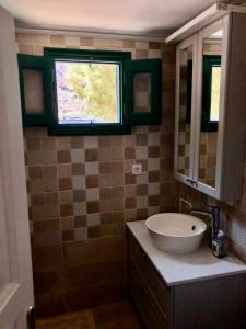 une salle de bain avec un lavabo et une fenêtre dans l'établissement La DESIRADE, à Symi