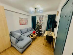 a living room with a blue couch and a christmas tree at Bakuriani Bliss Apartment in Bakuriani