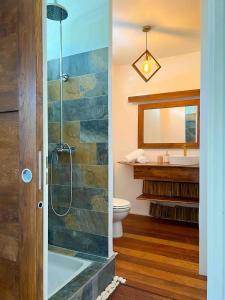 ein Badezimmer mit Dusche, Toilette und Waschbecken in der Unterkunft Manui Condo avec piscine et vue sur la mer et l'île de Moorea in Punaauia