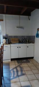 a kitchen with white cabinets and a sink at L'Essentiel in Arbusigny