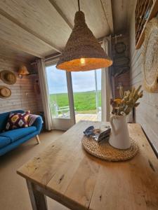 a room with a table with a vase of flowers on it at Surf Shack in Scharendijke