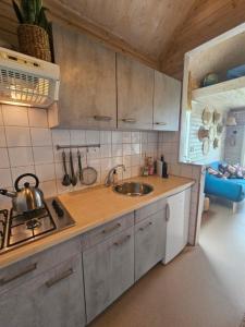 a kitchen with a sink and a stove top oven at Surf Shack in Scharendijke