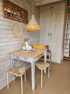 a table and chairs in a room with a light at Surf Shack in Scharendijke