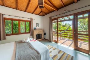 a bedroom with a bed and a fireplace at Coração da Terra Praia do Rosa in Praia do Rosa