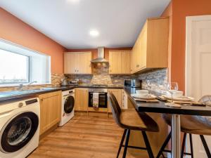 a kitchen with wooden cabinets and a table with chairs at 2 Bed in Falkirk 95833 in Bonnybridge