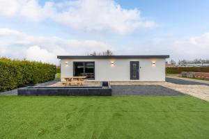 una casa bianca con tavolo da picnic e prato verde di Zenn in Style a Dronrijp