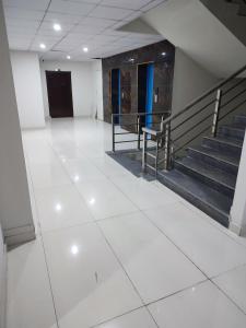 an empty room with stairs and a white floor at Raja residence in Islamabad