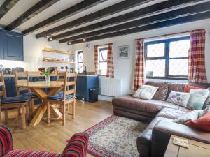 a living room with a couch and a table at The Studio Cottage in Cemaes Bay