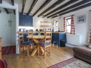 a kitchen and dining room with a table and chairs at The Studio Cottage in Cemaes Bay