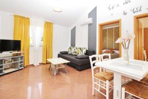 a living room with a couch and a table at Apartments Brnic Nara in Baška