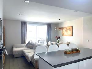 a living room with a white couch and white chairs at Dunas Beach II Apartment in Torrox Costa