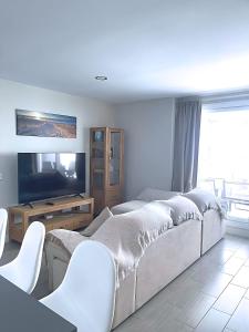 a living room with two beds and a flat screen tv at Dunas Beach II Apartment in Torrox Costa