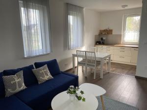 a living room with a blue couch and a table at Vitorlás Apartman in Balatonszárszó