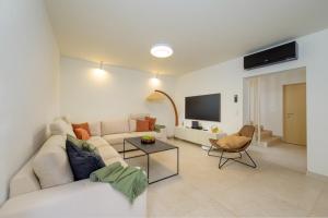 a living room with a white couch and a tv at Villa Vista Rovinj - NEW 2024 ! in Rovinj