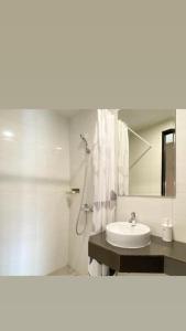 Un baño blanco con lavabo y espejo. en Our Home, en Jodoh