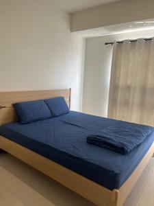 a bedroom with a bed with blue sheets and a window at Our Home in Jodoh +24 photos