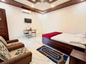 a bedroom with a bed and a chair and a table at LD Guest House, Ayodhya in Ayodhya