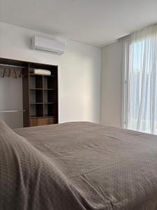 a white bedroom with a bed and a window at Casa delta mare in Isla Lucha +20 photos