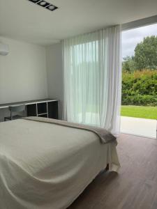 a bedroom with a bed and a large window at Casa delta mare in Isla Lucha