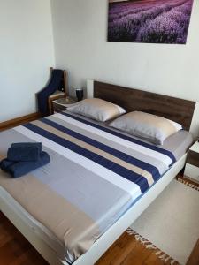 a bedroom with a bed with a blue and white blanket at Kuća za odmor SeaHouse in Karlobag +30 photos