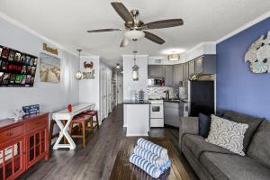 un soggiorno e una cucina con un divano e un ventilatore a soffitto di Hot tub Heated Pool Balcony Near Beach Balcony a Galveston