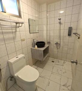 a white bathroom with a toilet and a shower at 綠島玉米-潛水住宿 Diveholix Homestay in Green Island +13 photos