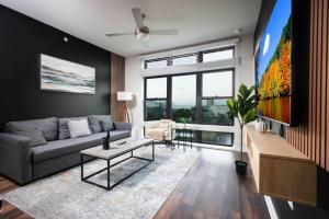 Una sala de estar con un sofá y un televisor. en Modern 2BR Getaway-w Parkng, Near Rvrwlk&Conv Ctr, en San Antonio