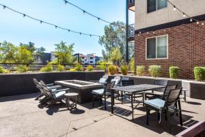 a patio with a table and chairs and a building at Stylish 2BR-Spring Training! w Pool, Gym & Parking in Tempe