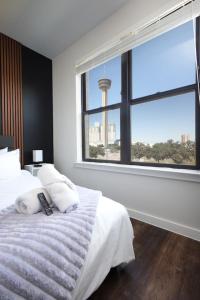 Un dormitorio con una cama y una ventana grande. en Stylish 2BR w Pool,Gym,Prking-Near Rvrwalk & Dome, en San Antonio