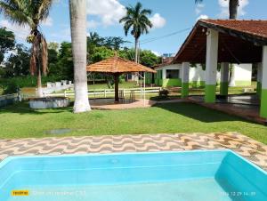 a swimming pool in a yard next to a house at Pousada Sossego in São José da Barra