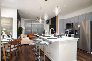 une cuisine et un salon avec un comptoir et des chaises dans l'établissement Elegant 2BR-w Parking, Near Riverwalk & Conv Ctr, à San Antonio