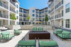 an apartment patio with chairs and a fire pit in front of buildings at Modern 1BR w Parking, Near Temple Square & Delta Center in Salt Lake City