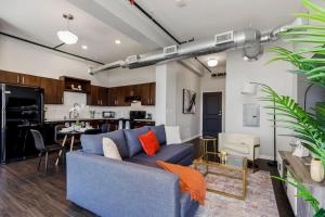 a living room with a blue couch and a kitchen at Chic 2BR-Parking, Rooftop,Near Arrowhd & TMobile in Kansas City