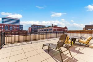 a patio with two chairs and a table on a balcony at Chic 2BR-Parking, Rooftop,Near Arrowhd & TMobile in Kansas City