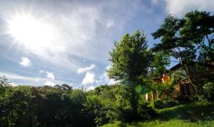 una casa en un campo con el sol en el cielo en Amaraka Lodge en Leandro N. Alem